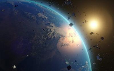Earth in the foreground and the sun in the background, with space debris floating around
