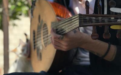 A person holding an Oud - a wooden lute-like instrument with strings
